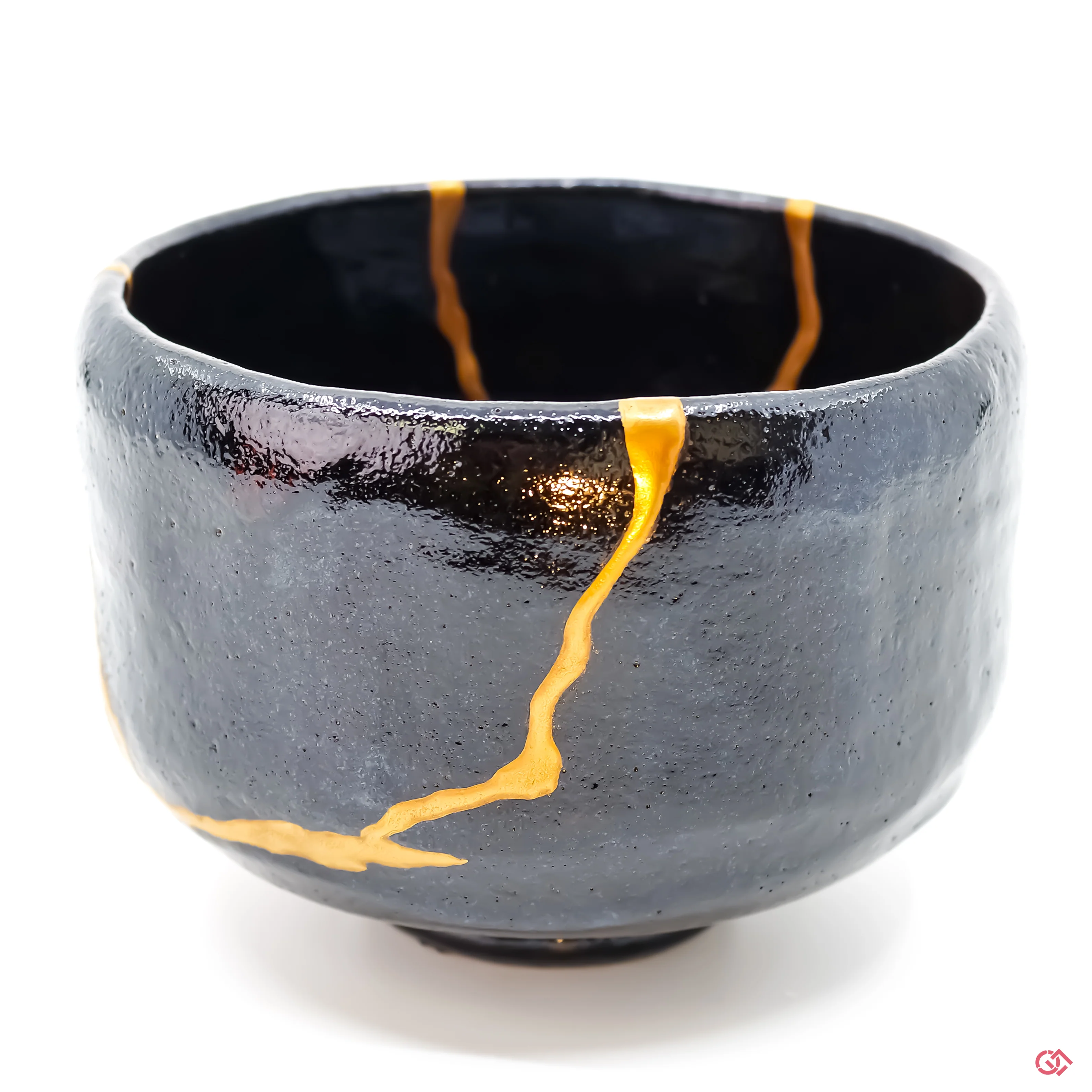 Hand-fired Japanese tea bowl with authentic gold Kintsugi repair on weathered wood pedestal